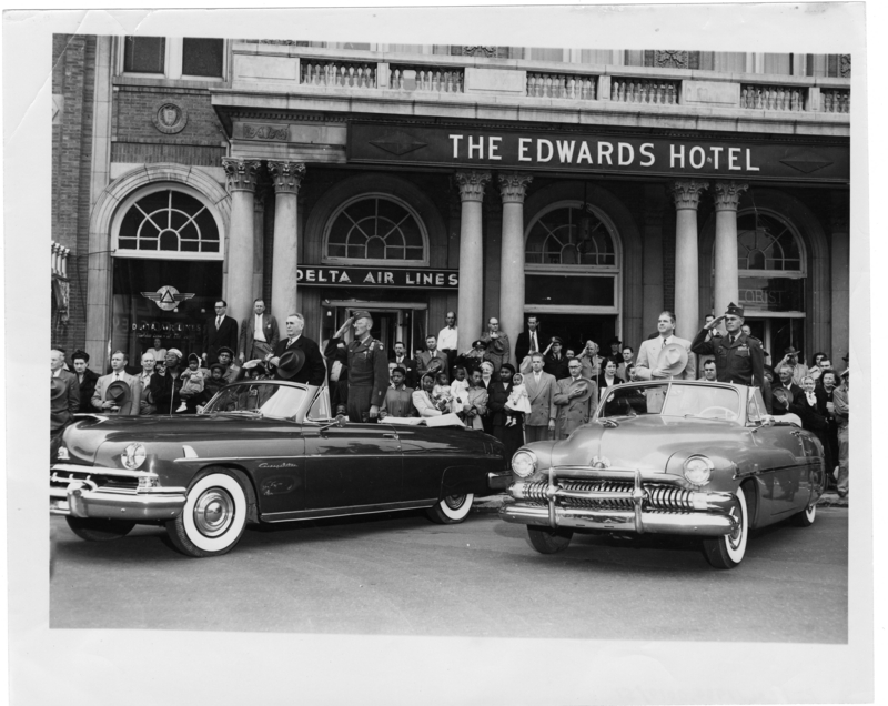 Gov. White, Mayor Thompson and military officers salute from convertible automobiles parked in front of The Edwards Hotel. Call Number: PI/COL/1984.0019, item 51 (MDAH)